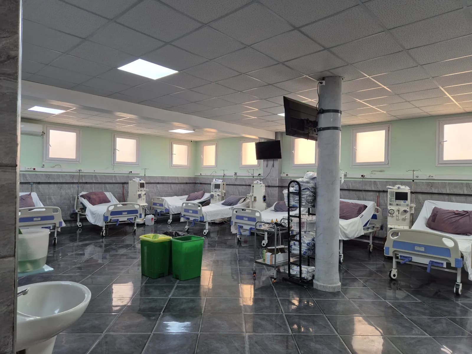 Salle d'hémodialyse de la Clinique ESSAADA à Sidi Bel Abbès — vue large des postes alignés équipés de générateurs et lits inclinables, prête pour les séances Ramadan adaptées